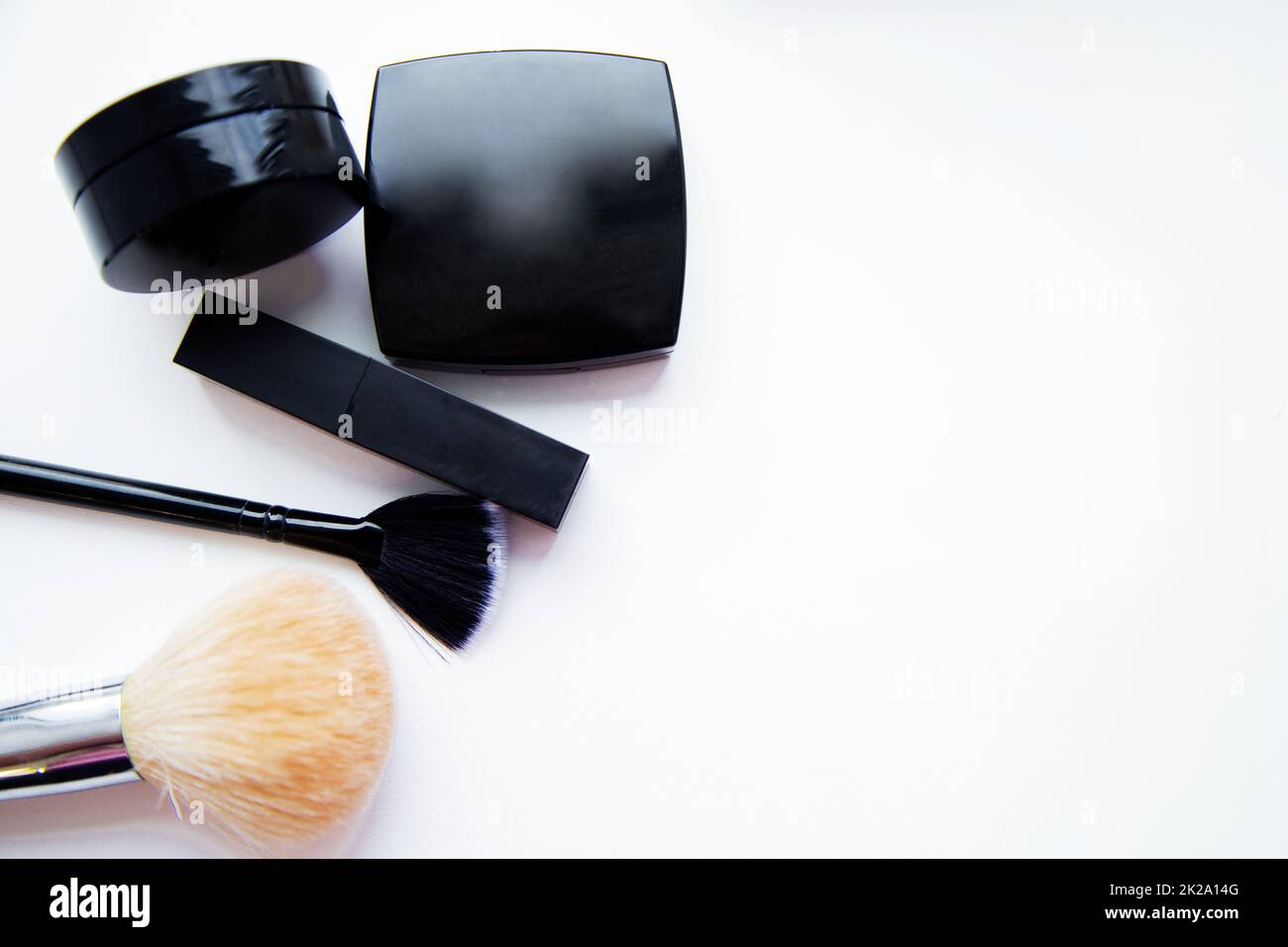 Lipstick and face powder and brush lying together on white background with place for text Stock Photo