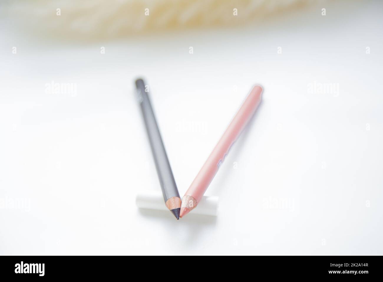 Two pencils for eyes and lips lie together on a white background Stock Photo