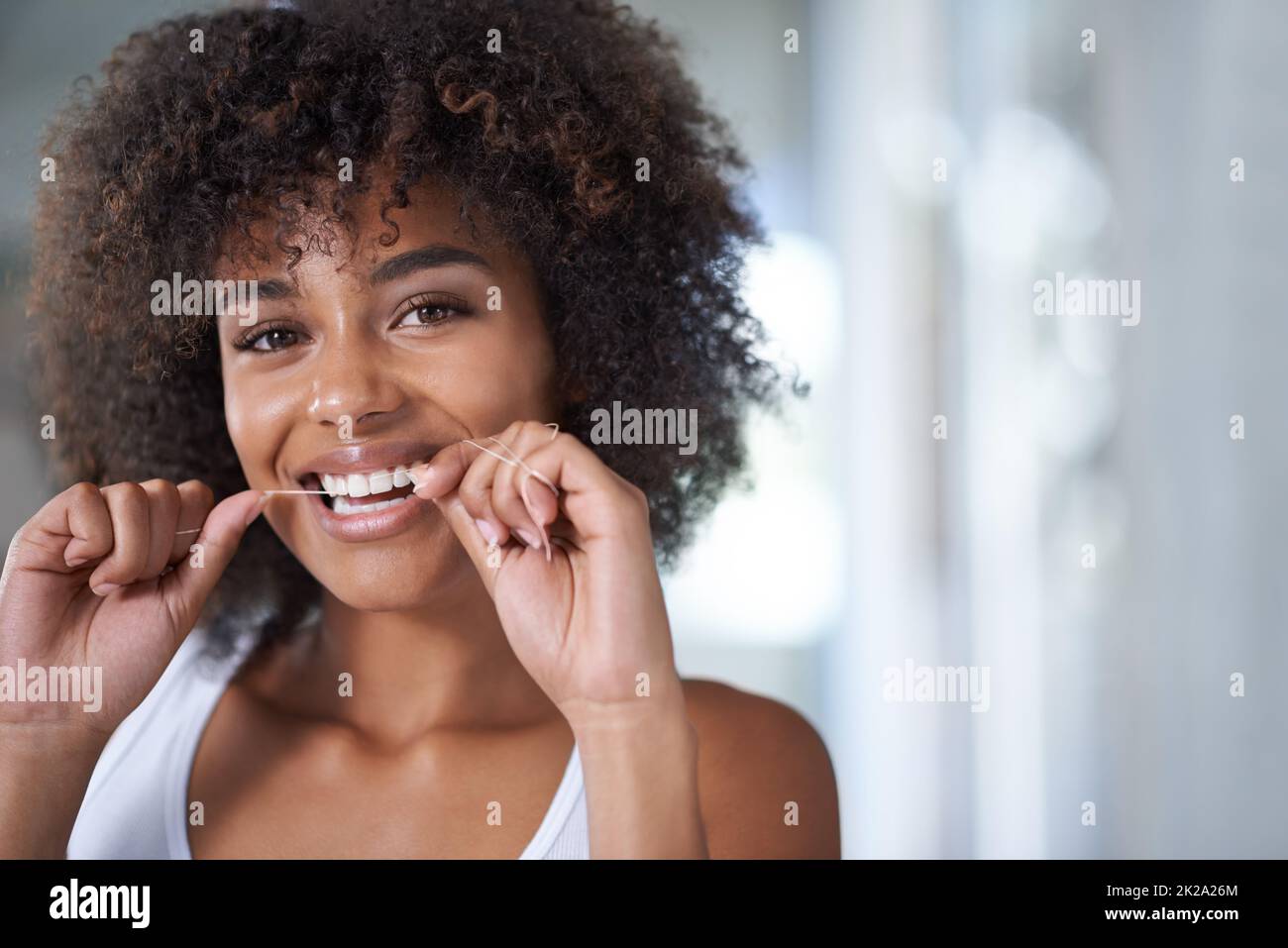 Getting those hard to reach places. Shot of a young woman flossing her