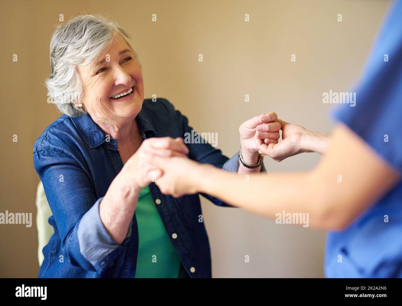 Let me give you a hand. Shot of a resident and a nurse at a retirement home. Stock Photo