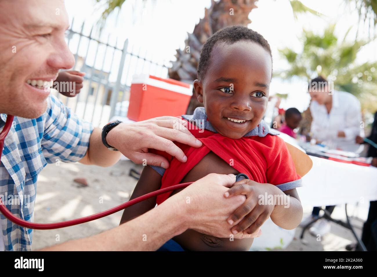 Every child deserves a healthy start in life. Shot of a volunteer doctor giving checkups to underprivileged kids. Stock Photo