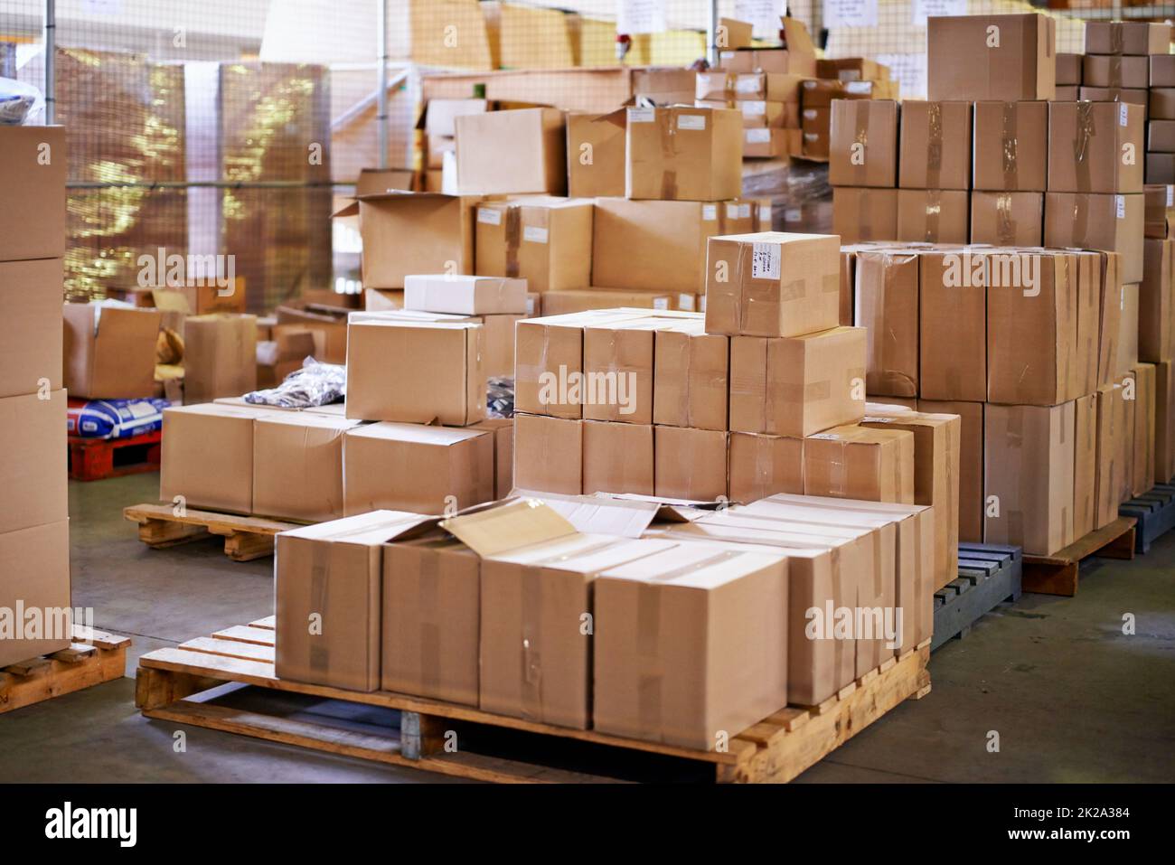 Pallets ready to go. Shot of stacked boxes in a large distribution warehouse. Stock Photo