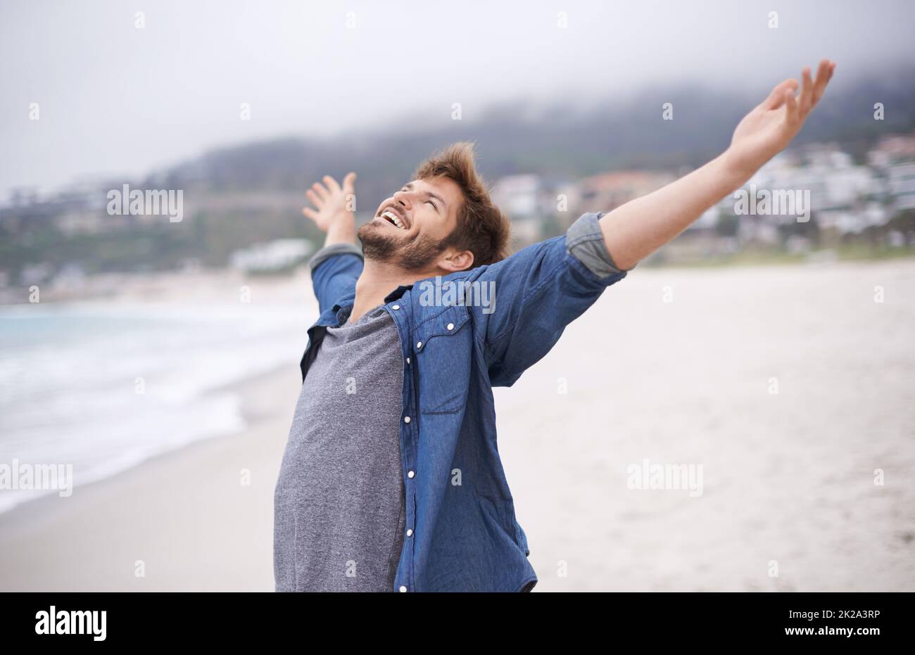 Aint life grand. Shot of a carefree young man throwing his arms back in joy. Stock Photo
