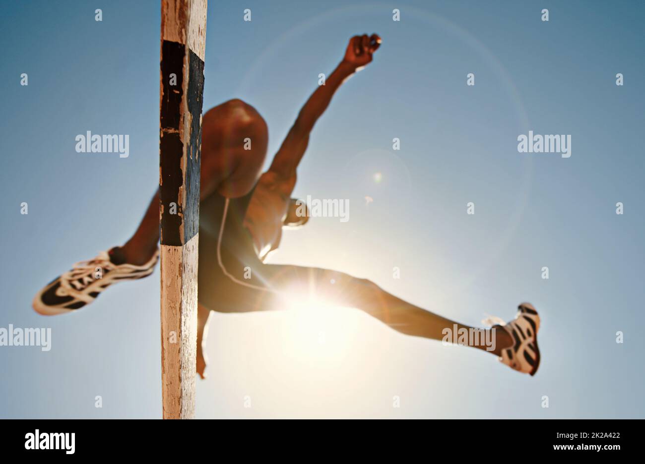 Know your limitations and defy them. Low angle shot of an athletic practicing high jump. Stock Photo