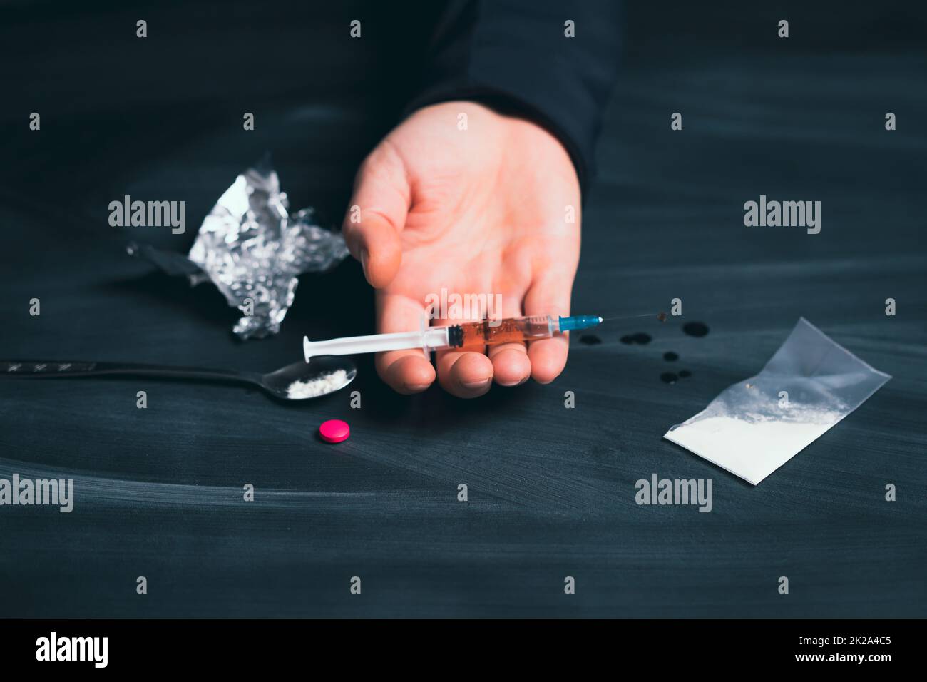 Addict man with syringe using drugs. Stock Photo