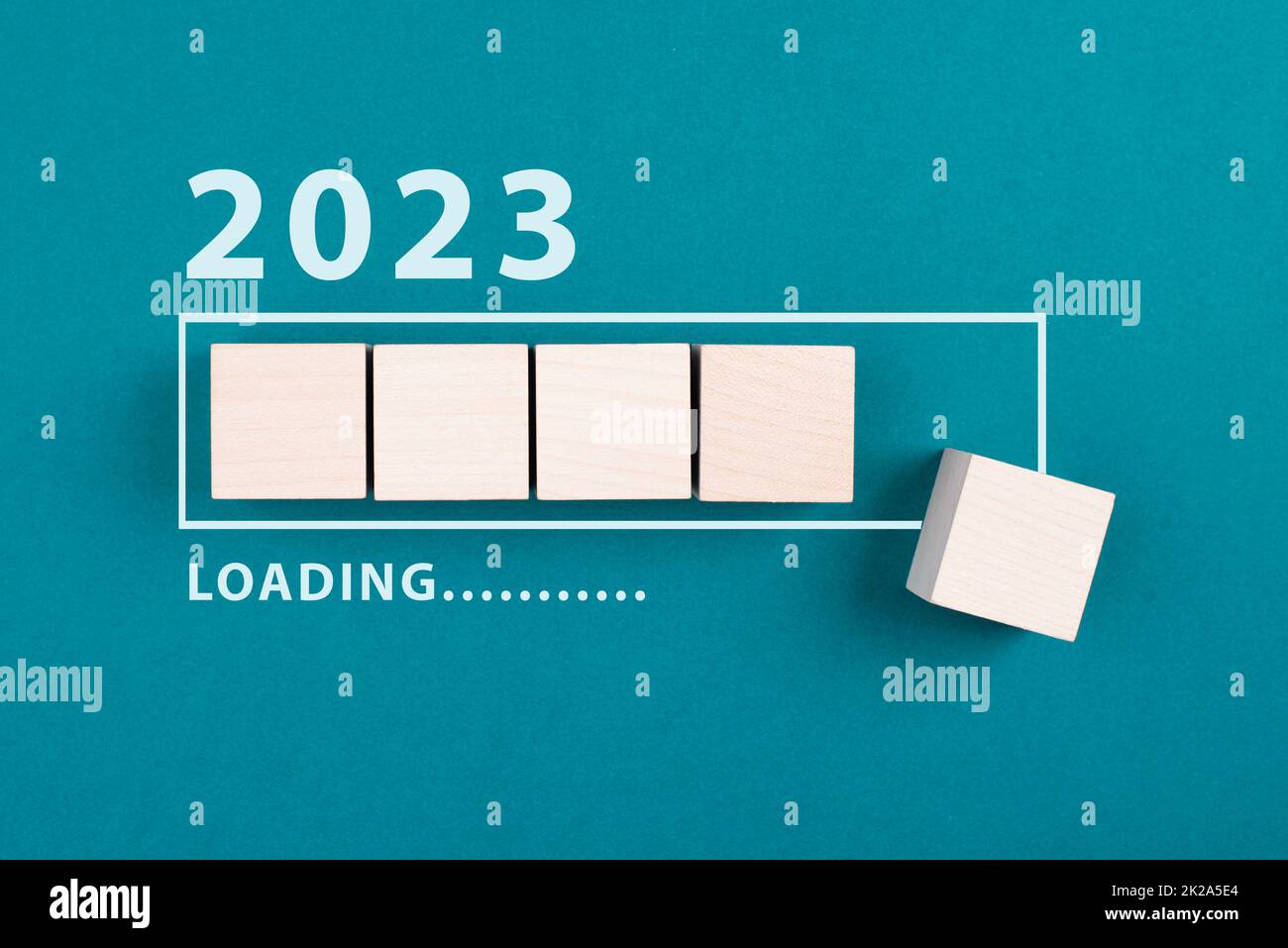 The new year 2023 is standing on a petrol colored background, loading bar with wooden cubes, calendar date Stock Photo