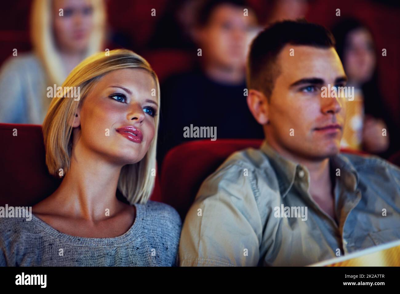 Date night. A cute young couple watching a movie in a cinema together. Stock Photo