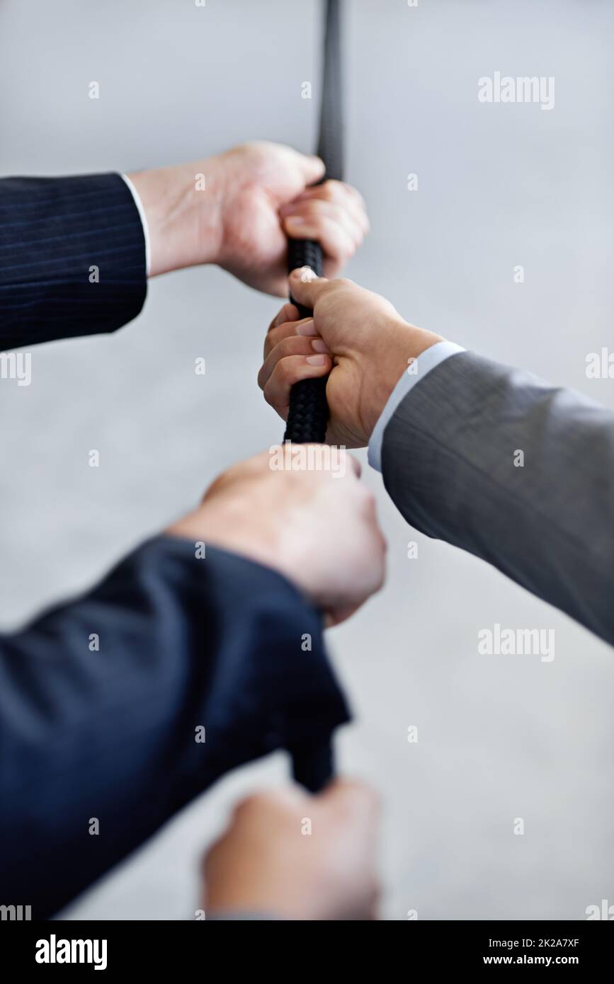 Theyre a competitive team. Closeup studio shot of two businessmen pulling a rope. Stock Photo
