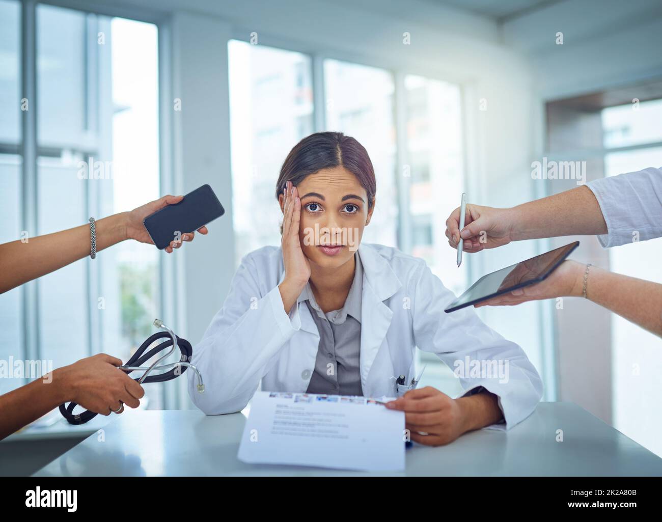 Its too chaotic to cope. Portrait of a young female doctor looking stressed out in a demanding work environment. Stock Photo