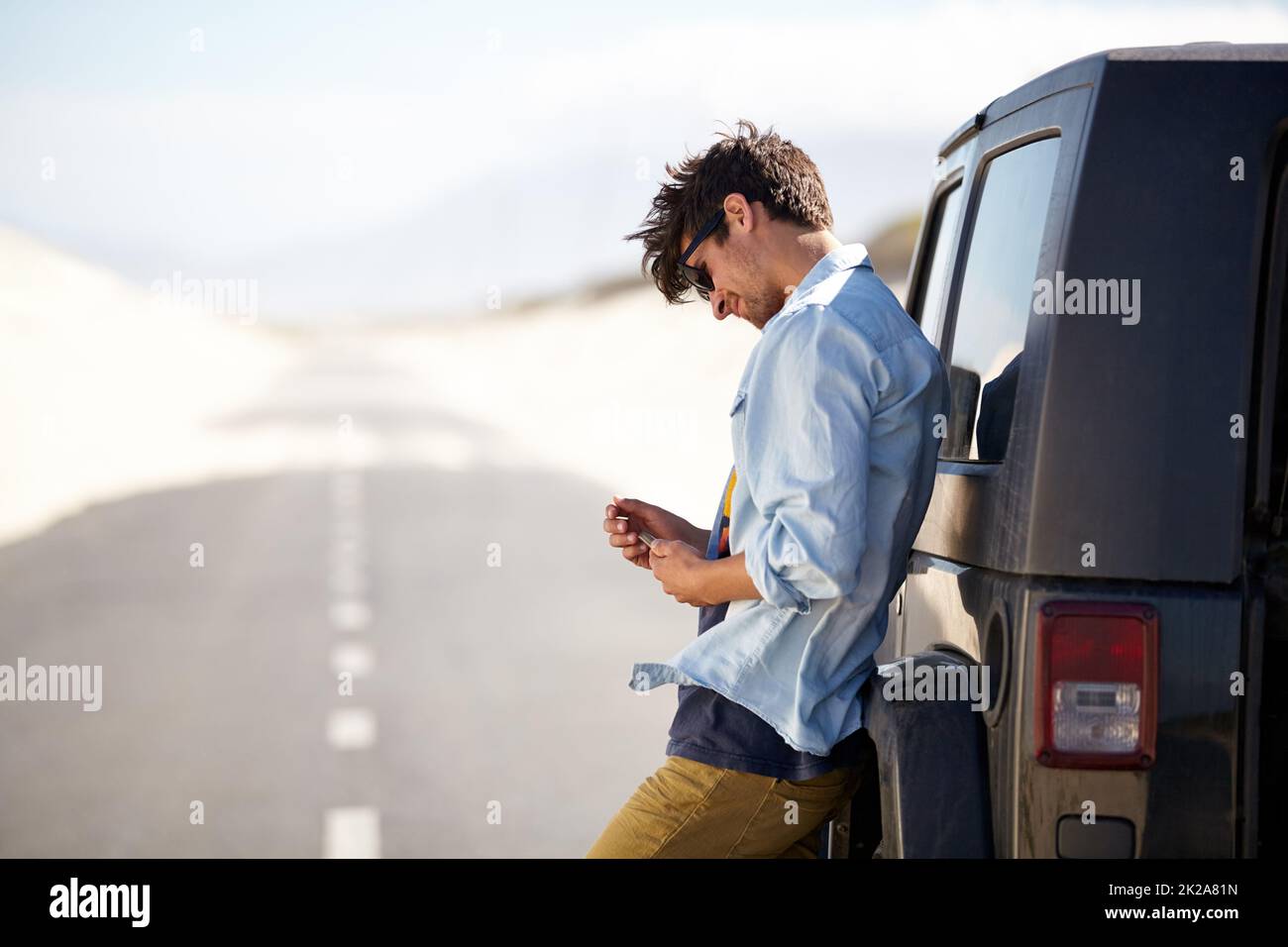 I need a little help out here. A young man phoning for roadside assistance. Stock Photo