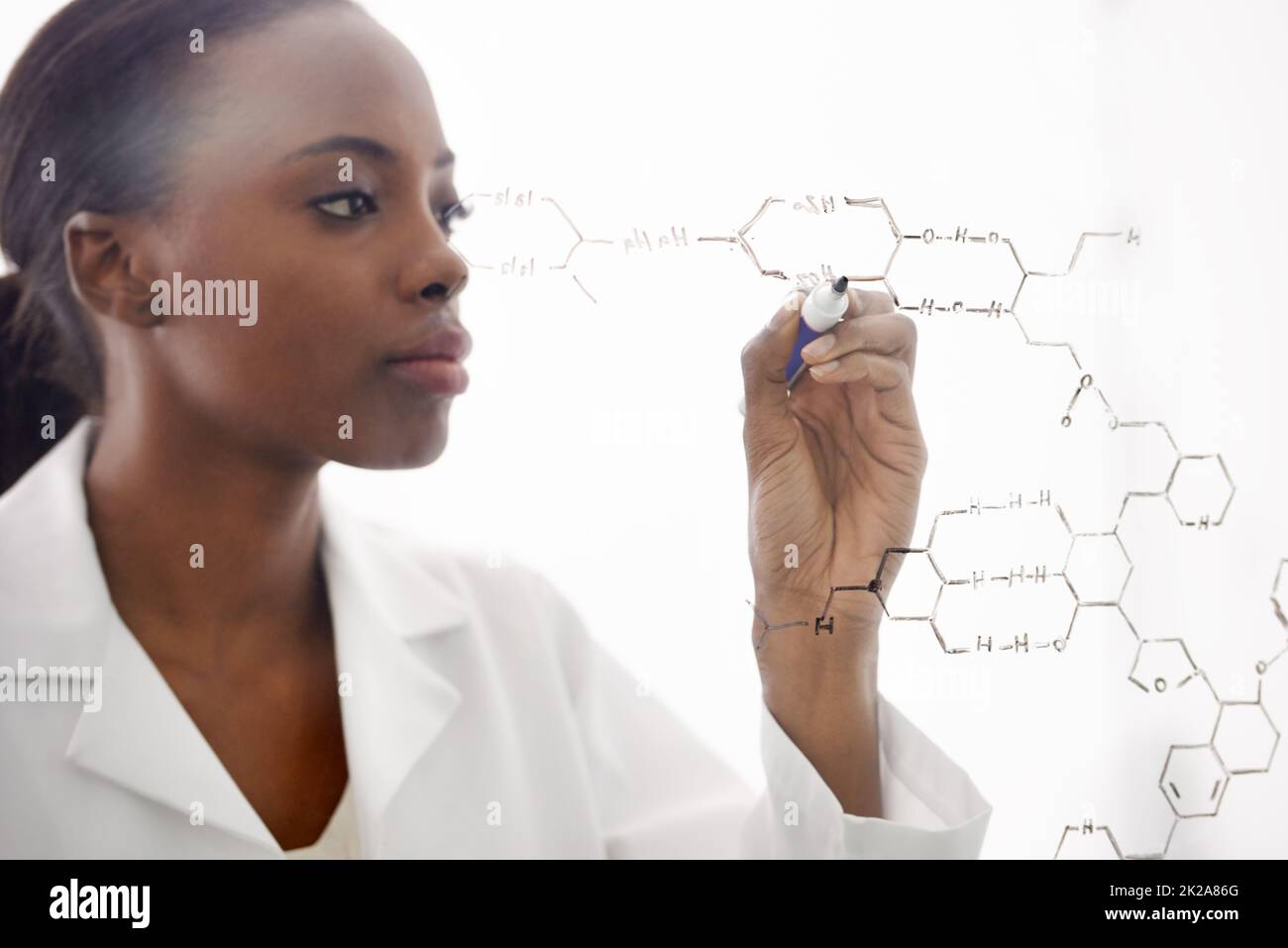 The world of molecules. Shot of a handsome male scientist drawing chemical bonds on a glass surface. Stock Photo