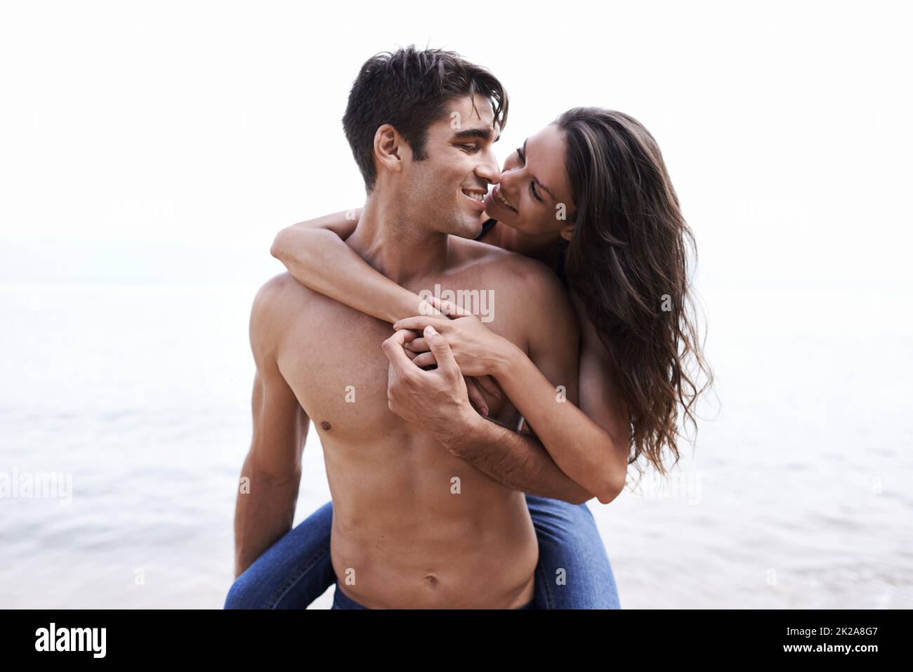 Young man giving his girlfriend a piggyback ride on the beach - a Royalty  Free Stock Photo from Photocase