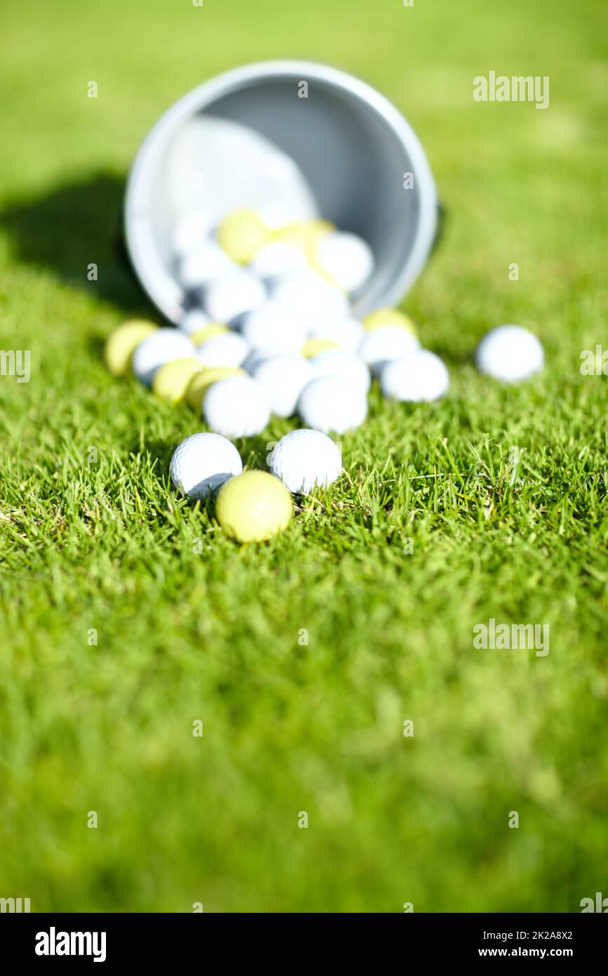 Picking the correct golf ball is important. Shot of a bucket of golf