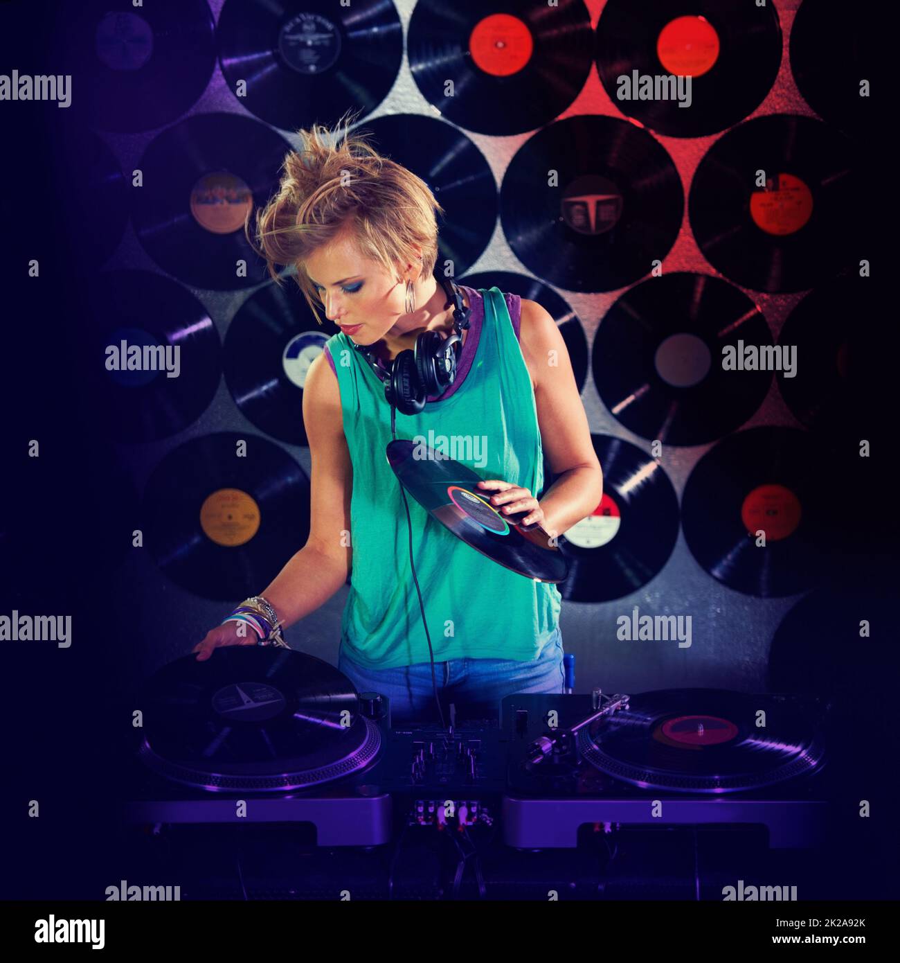 Listening to her own beats. A young female dj listening to some mixes