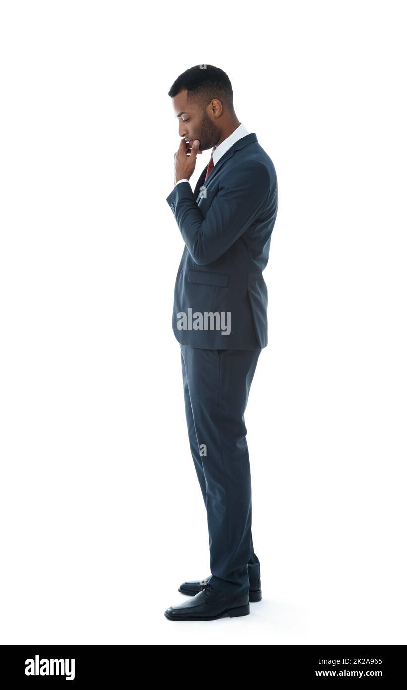 Worried about his job. A serious young businessman looking down while thinking - Isolated on white. Stock Photo