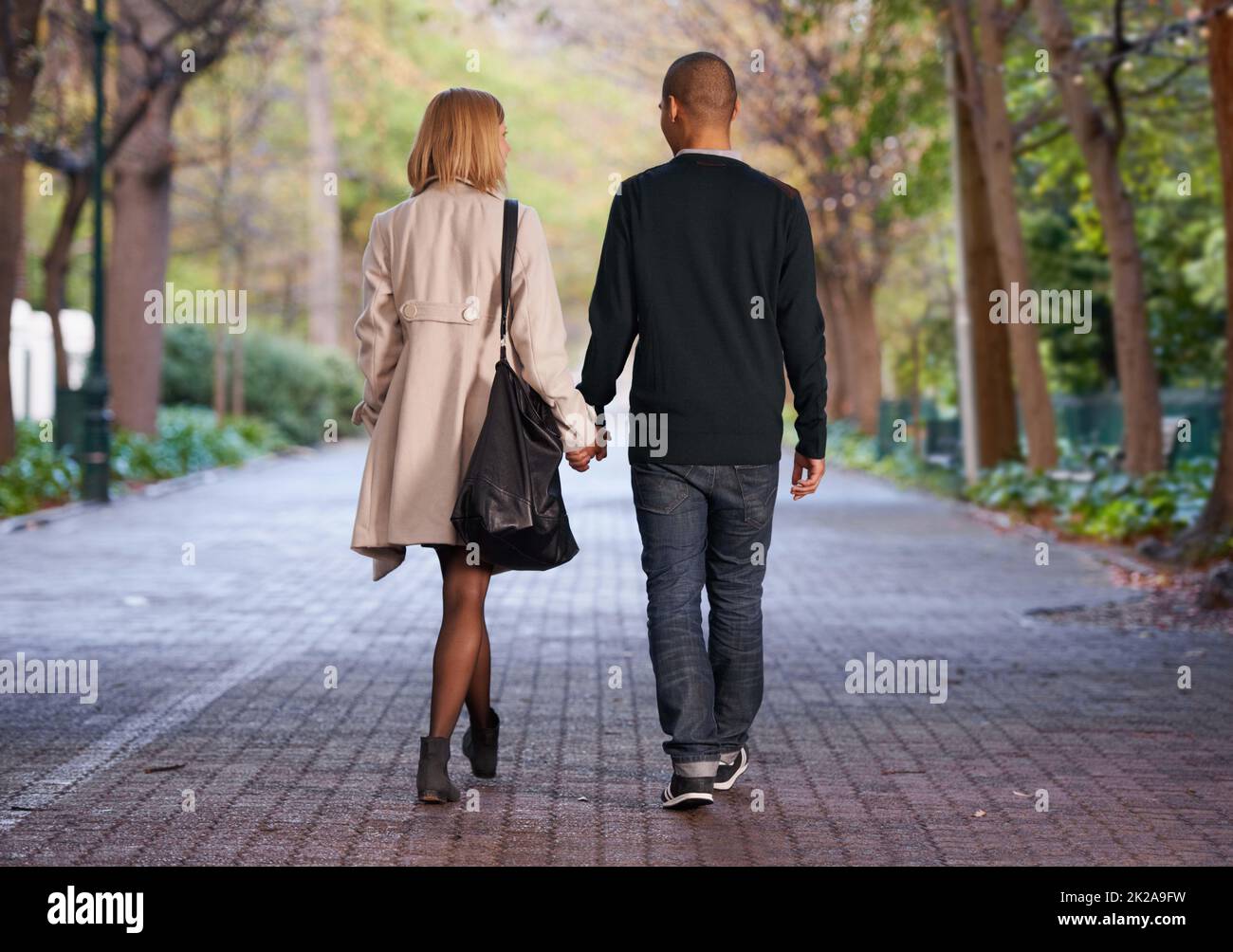 This is what love is all about. Full length rearview shot of a young couple walking hand in hand in a park. Stock Photo