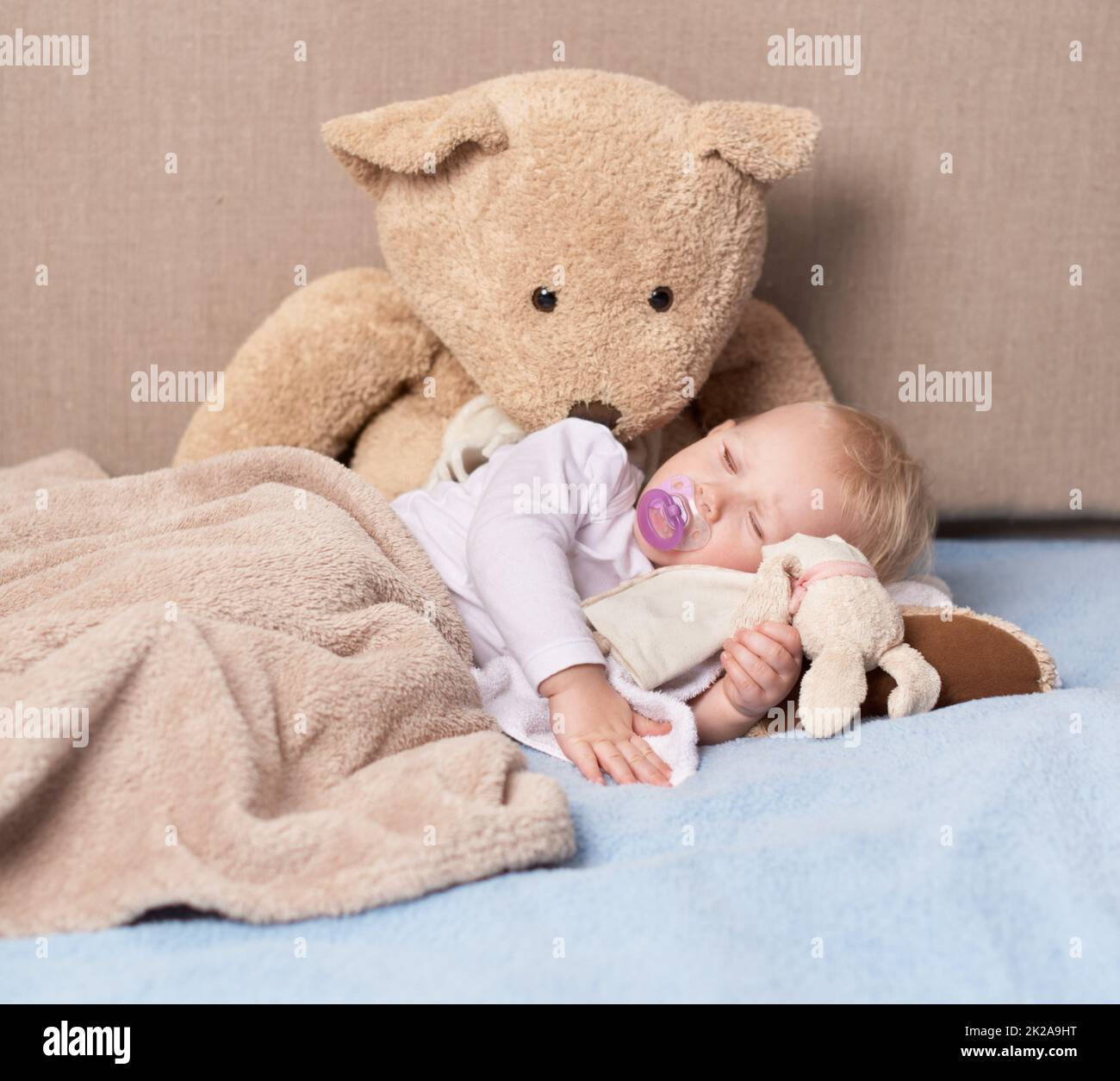 Sleeping angel. Shot of an adorable baby girl sleeping with her toys. Stock Photo