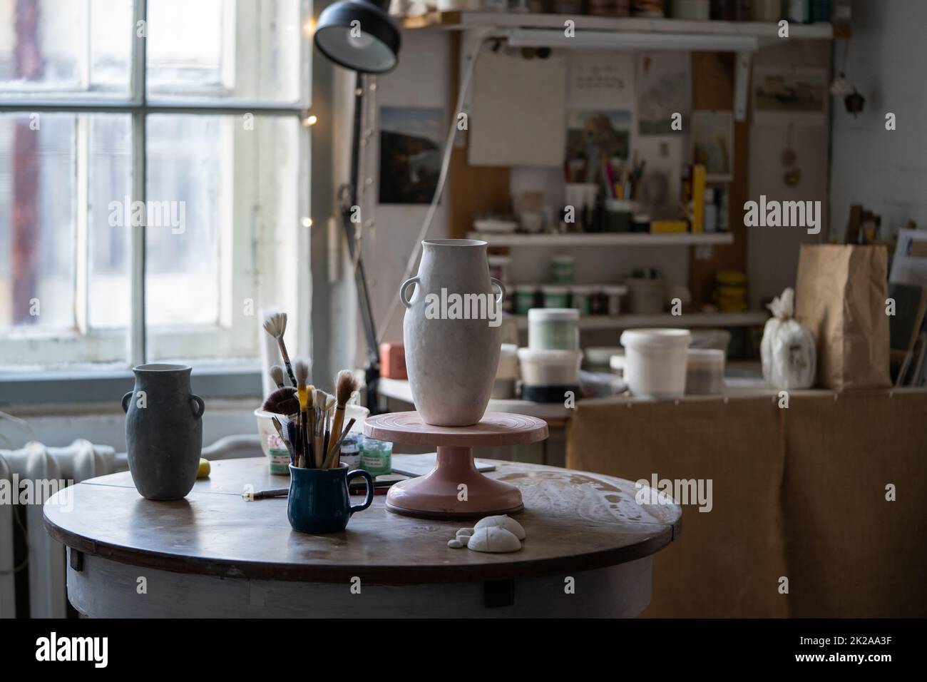 Clay vase stands on wooden rack drying up on table and prepared for sketch for exhibition in museum Stock Photo