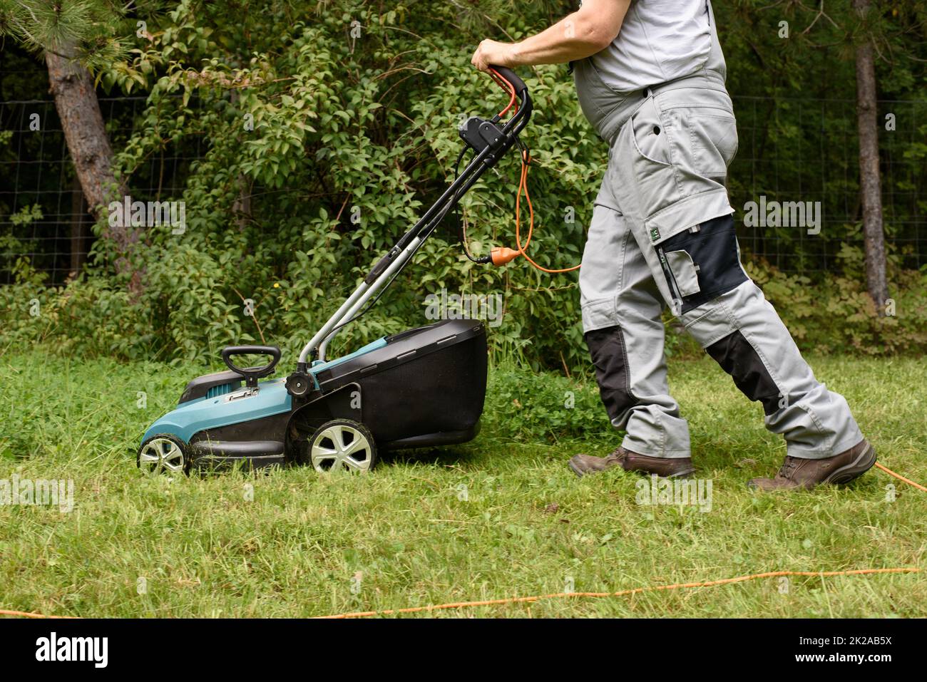 Man Mowing Lawn in garden Stock Photo