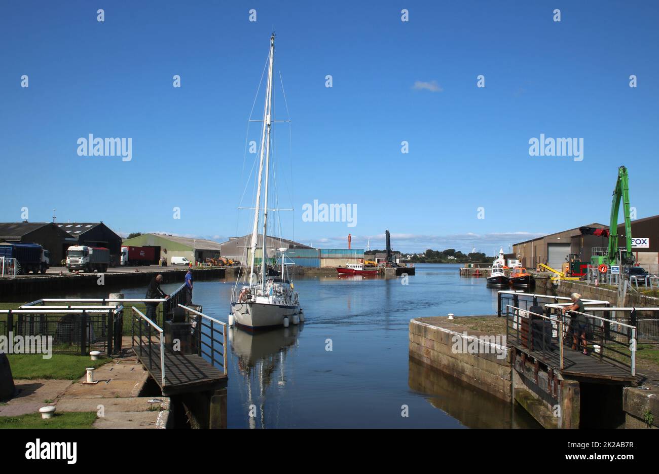 Yacht entering Glasson Dock heading towards the open lock gate on the connection between the Dock and the canal basin September 2022. Stock Photo