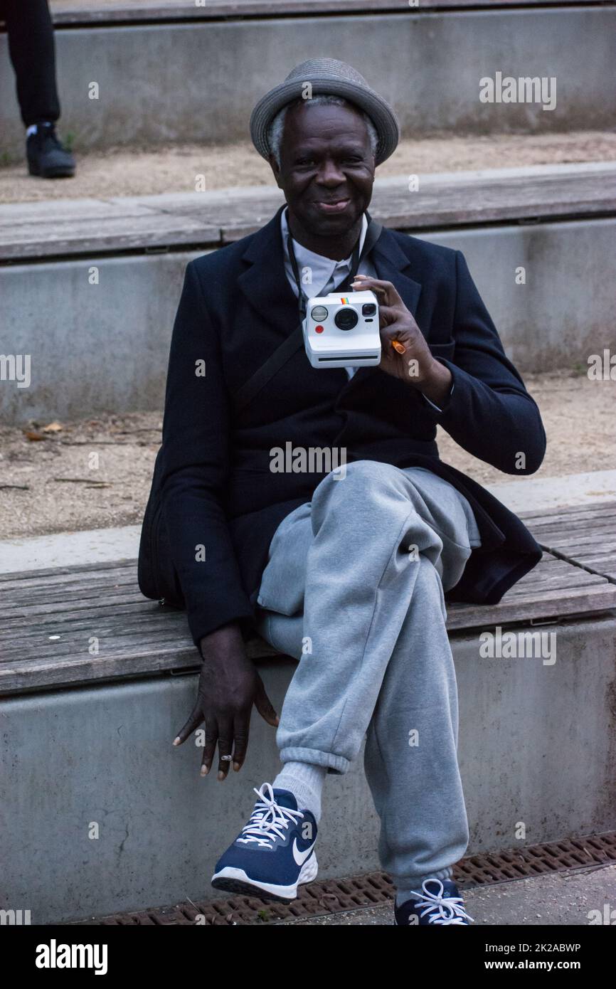 London, UK. 22 September 2022. A old guy with a Polaroid Film camera watching Dystopia to Utopia: Reimagining our future at Carpenter's Lock, Queen Elizabeth Olympic Park. Stock Photo
