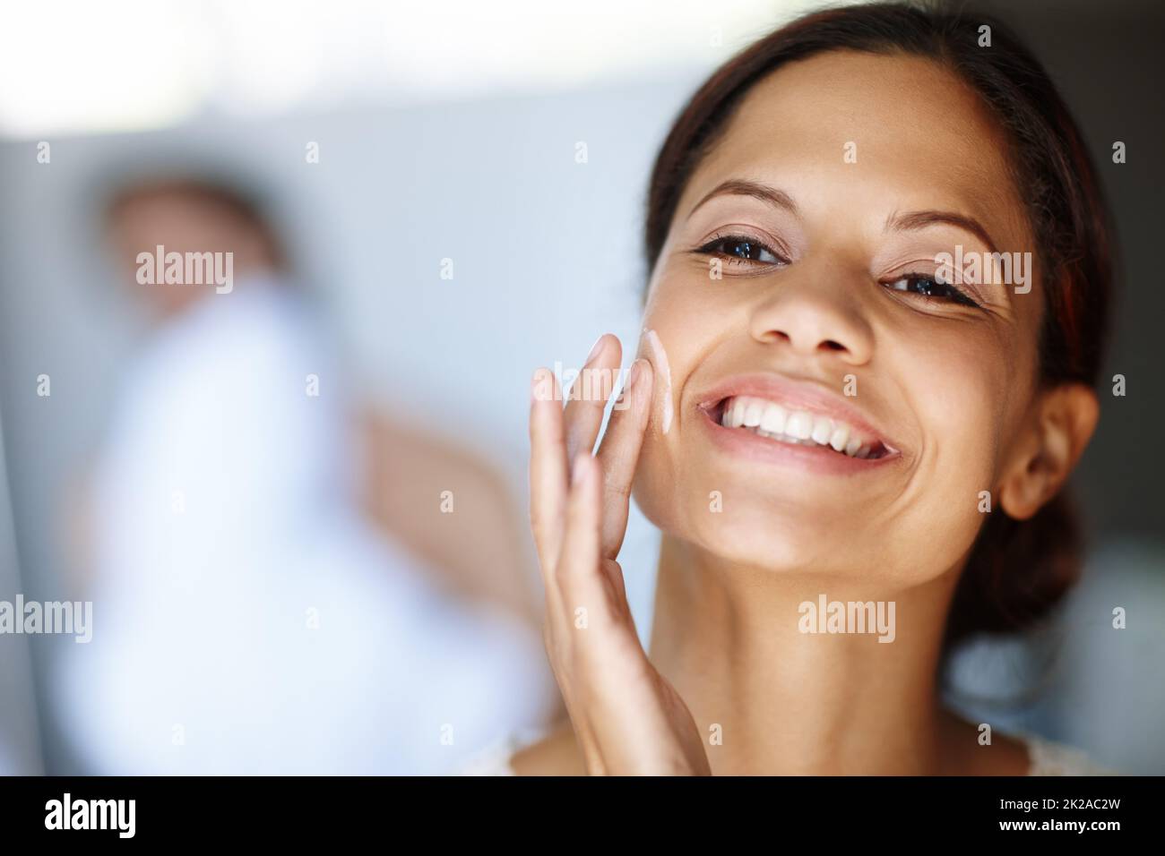 Giving her skin all it needs. An attractive young woman taking care of
