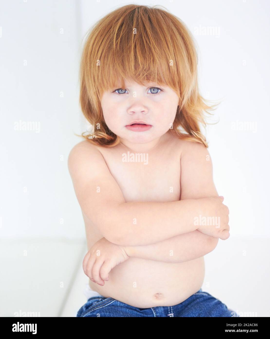 Shes feeling grumpy. A cute baby looking miserable with her arms folded
