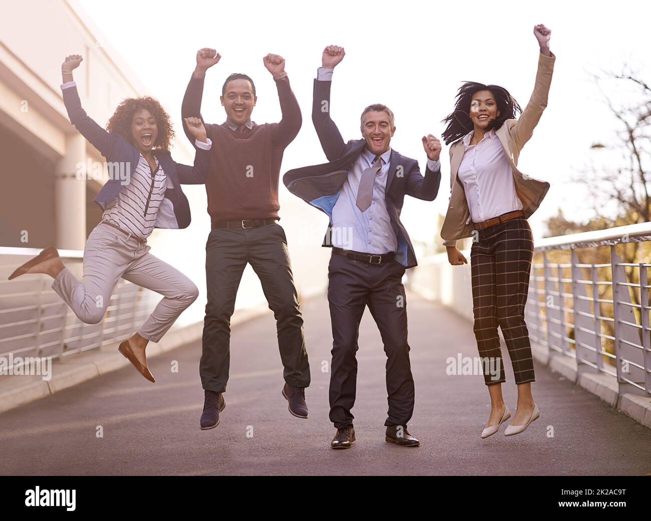 The triumphant team. A group of businesspeople jumping with excitement outside. Stock Photo