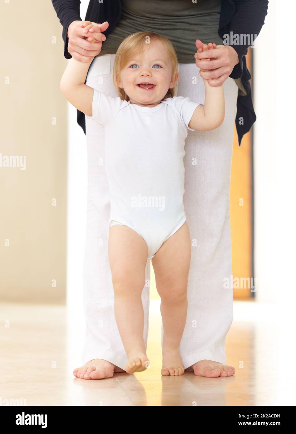 Magic moment. A cute baby learning to walk. Stock Photo