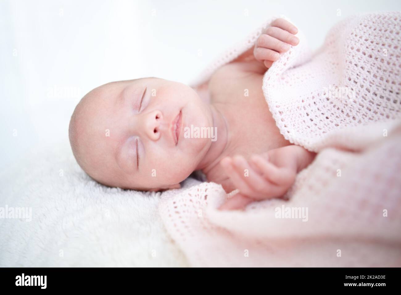 Peaceful sleep. A beautiful infant girl sleeping while wrapped up in a