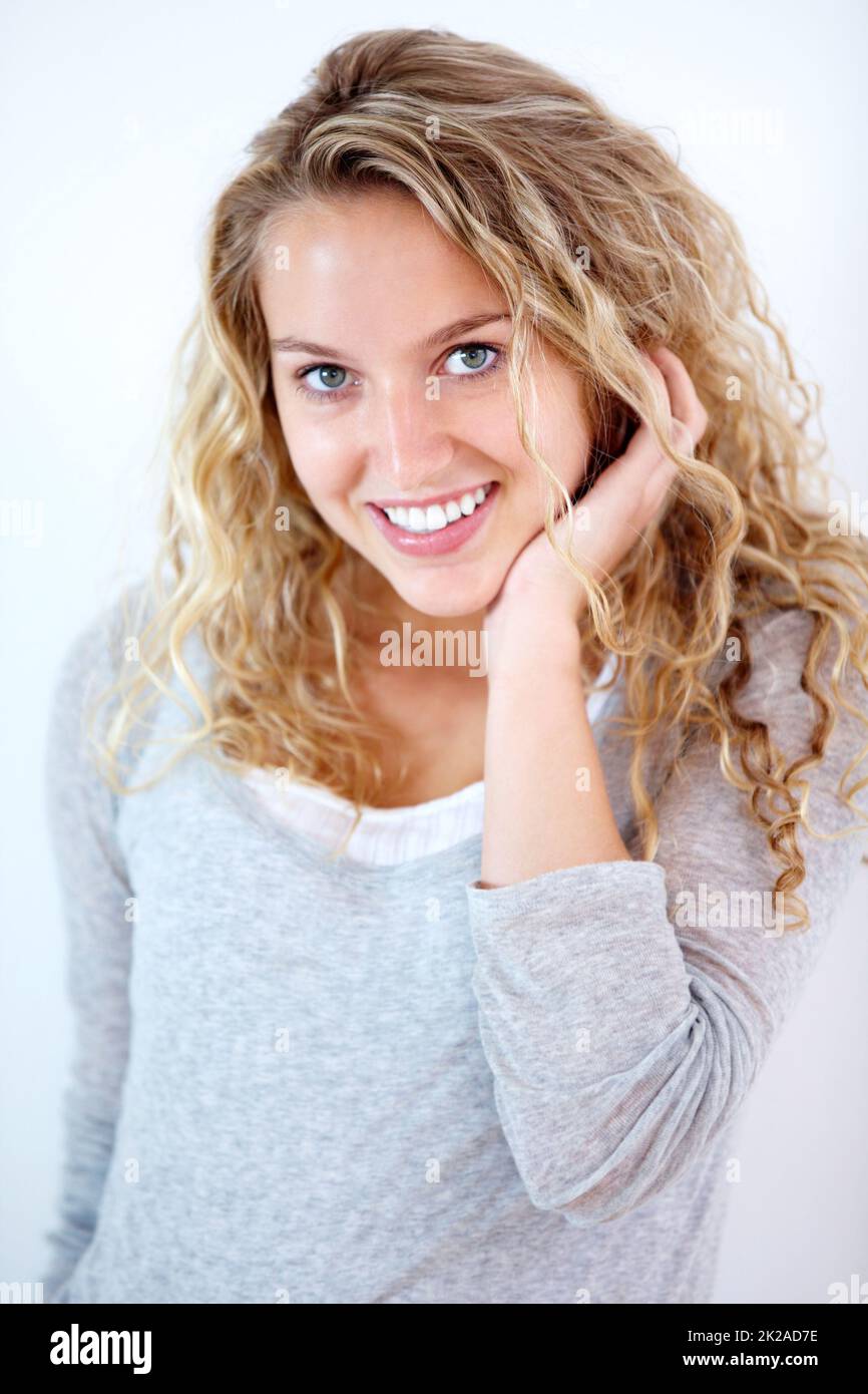 A pretty, sweet smile. Portrait of a pretty young blonde smiling at you sweetly. Stock Photo