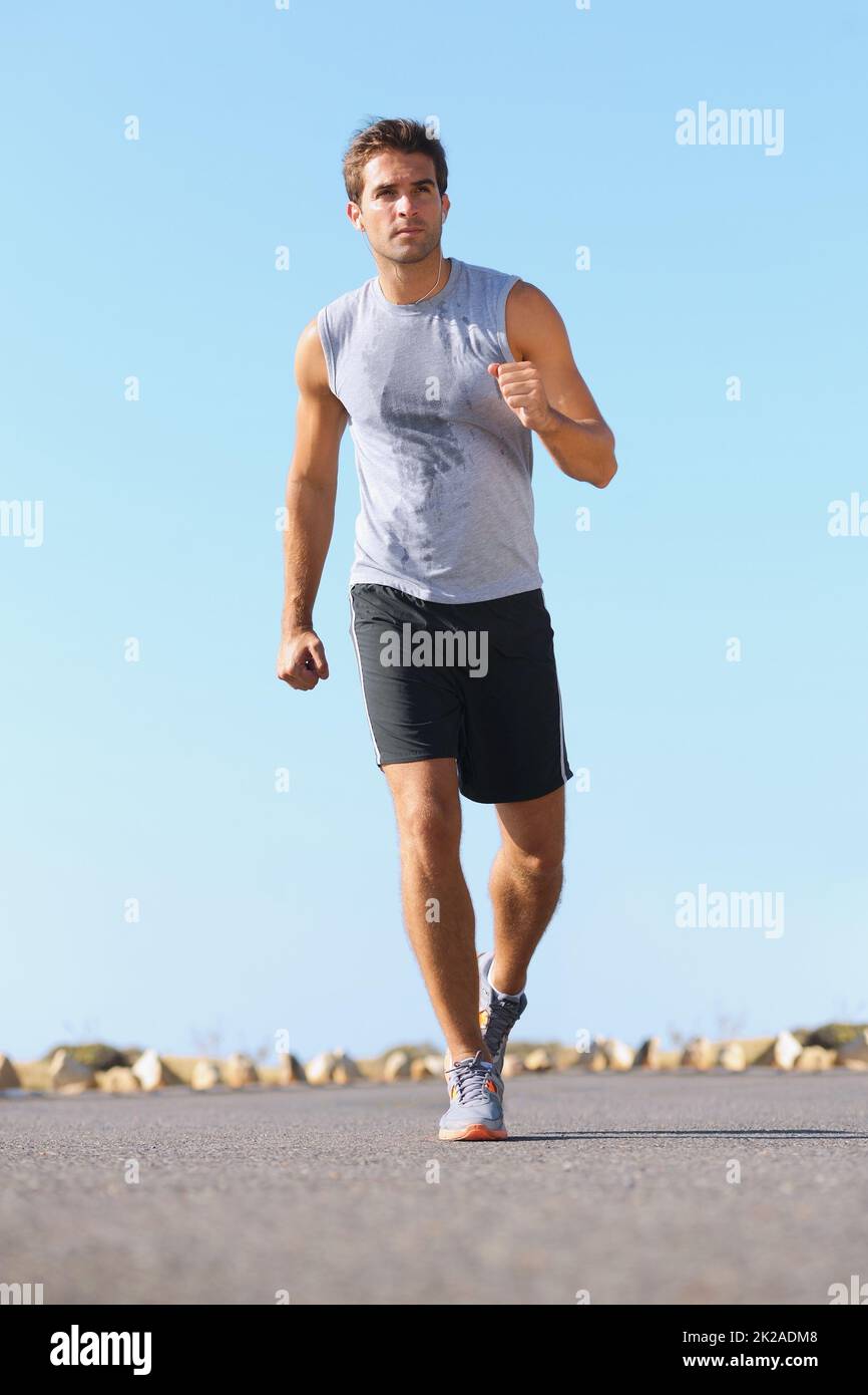 Keeping his body in great shape. Handsome young man jogging down the
