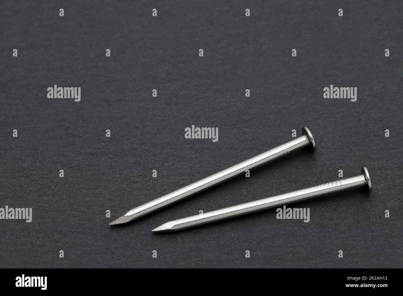 silver metallic nails on black background Stock Photo - Alamy