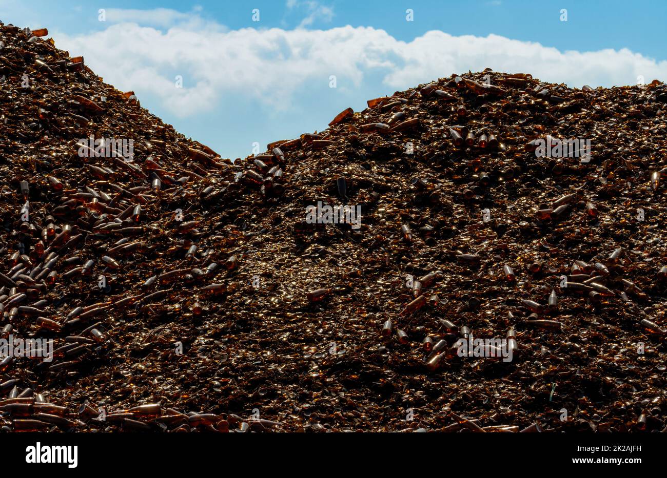 Pile of brown bottle for recycle in recycling factory. Glass waste for recycle. Dump of brown beer and wine glass bottle. Smashed glass bottle garbage. Recycling business. Sustainable glass packaging. Stock Photo