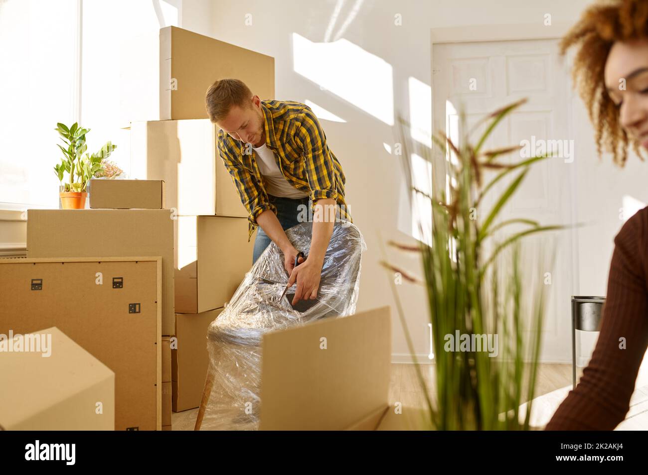 Smiling couple unpacking furniture in new home Stock Photo