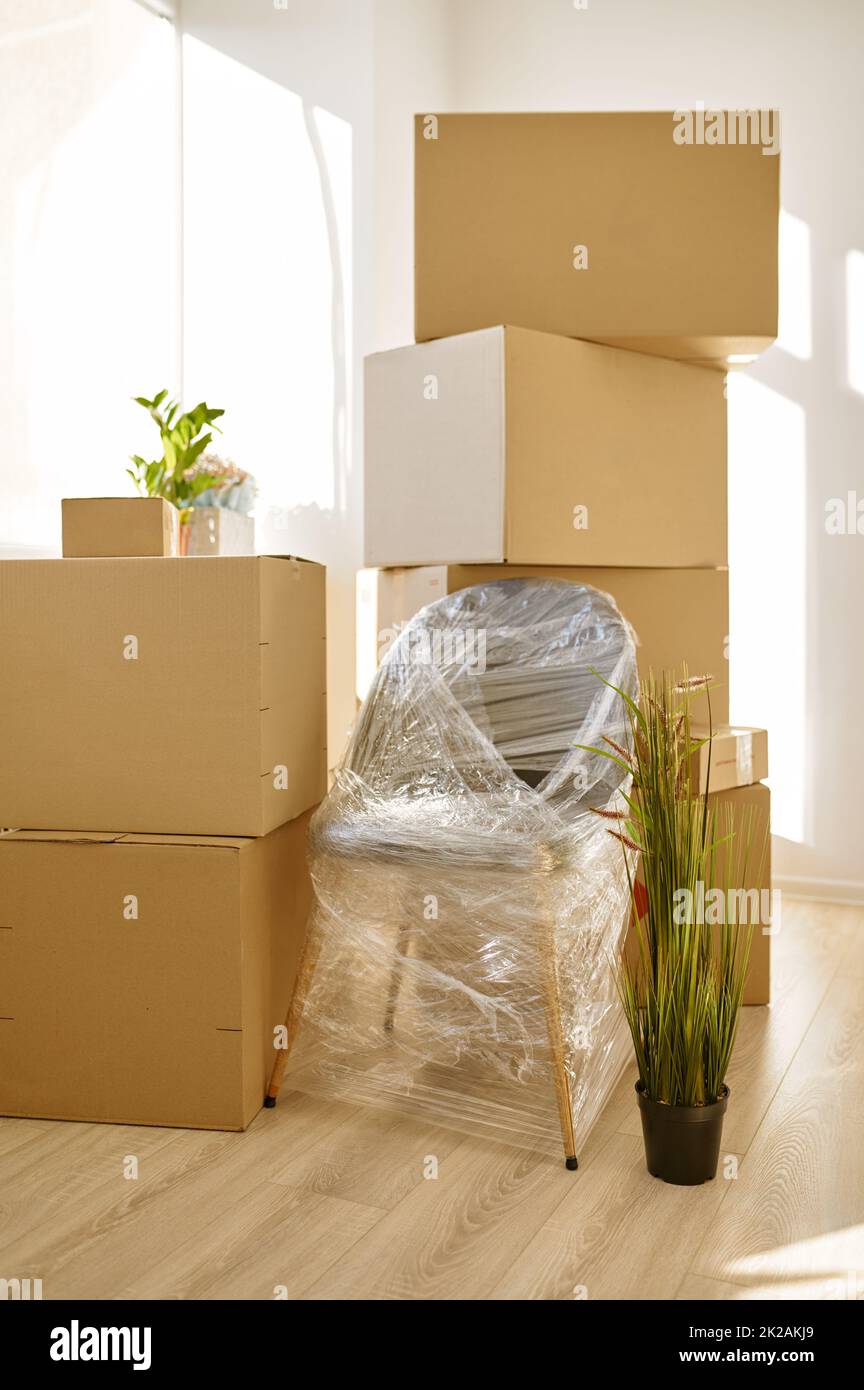 Stacked cardboard boxes and packed chair indoors Stock Photo Alamy
