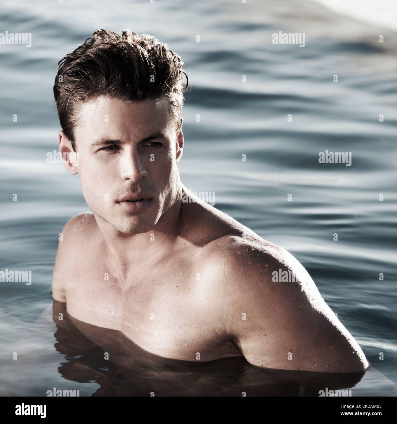 A moment to myself. A handsome male model in water looking to the side. Stock Photo