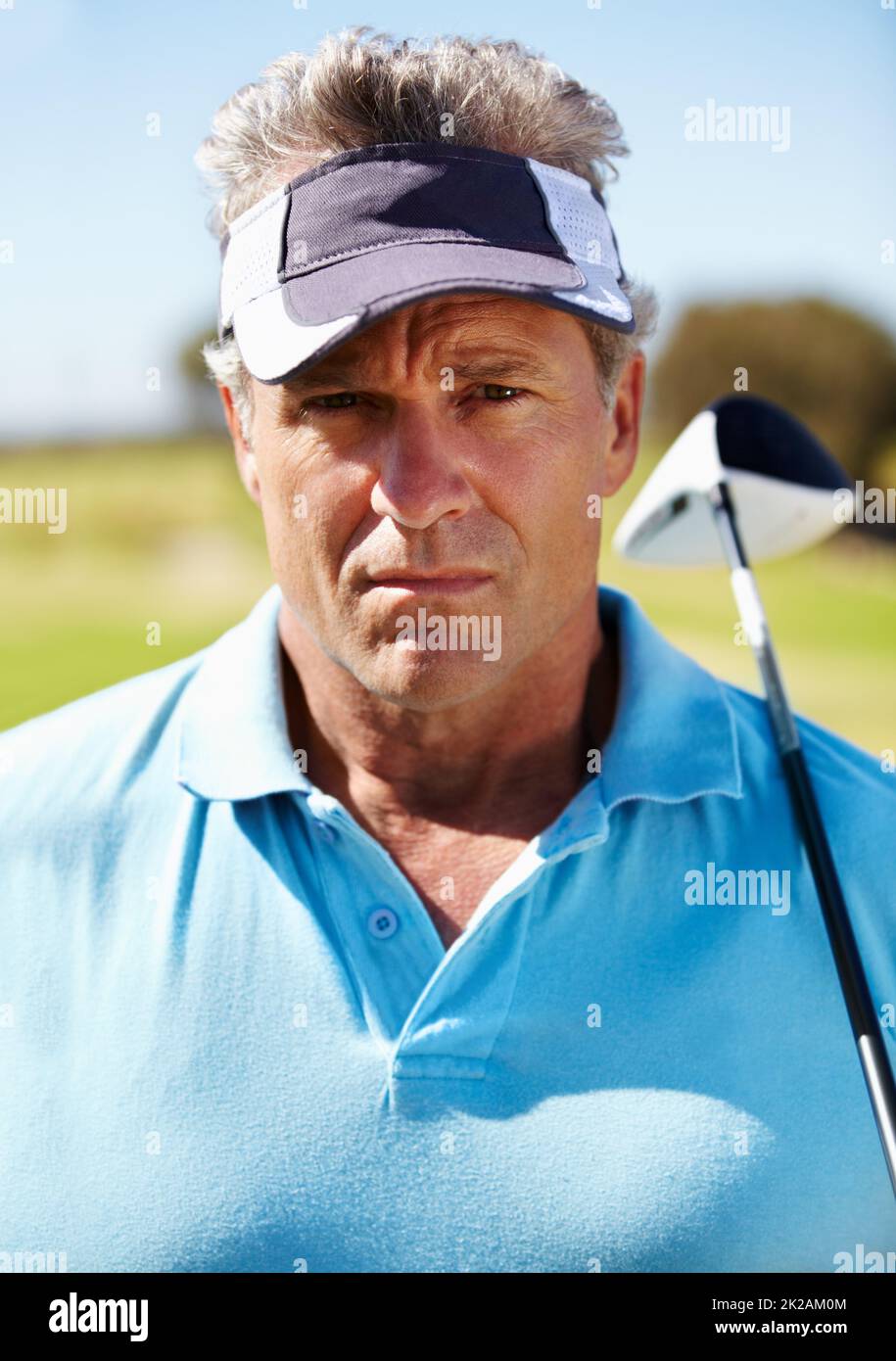 Serious about golf. Head and shoulders portrait of a mature golfer with his club over his shoulder. Stock Photo