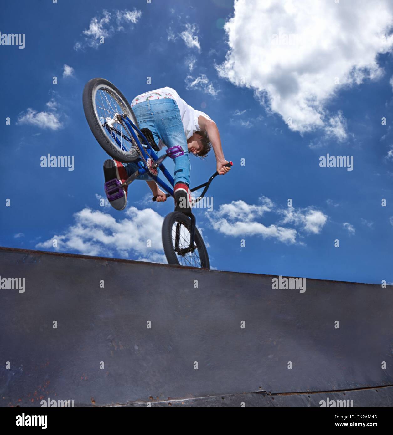 Practicing for the x games. Rearview shot of a teenage boy riding a BMX