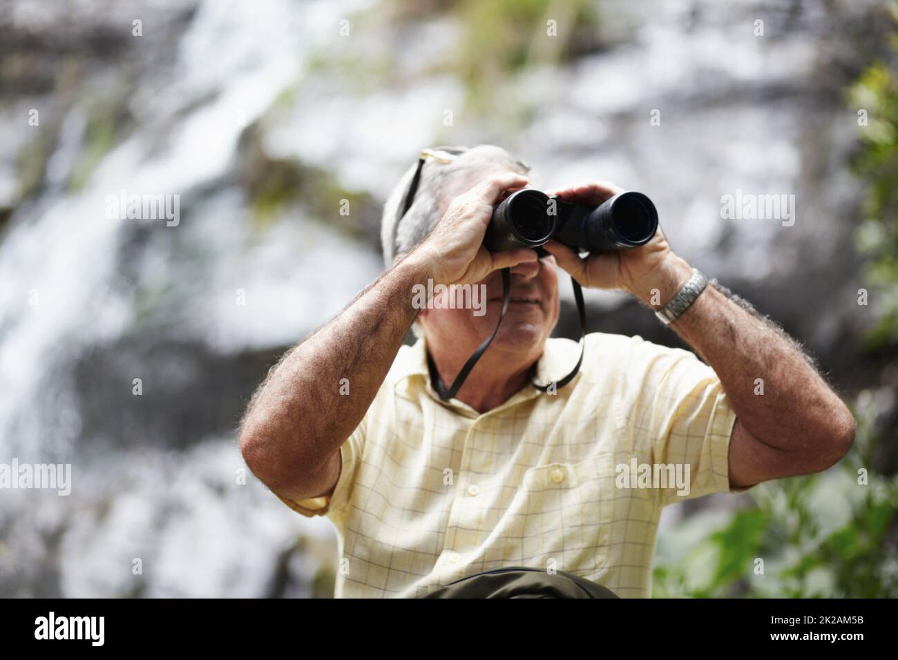 Its all in the little things. Shot of a senior man looking at scenery with a pair of binoculars. Stock Photo