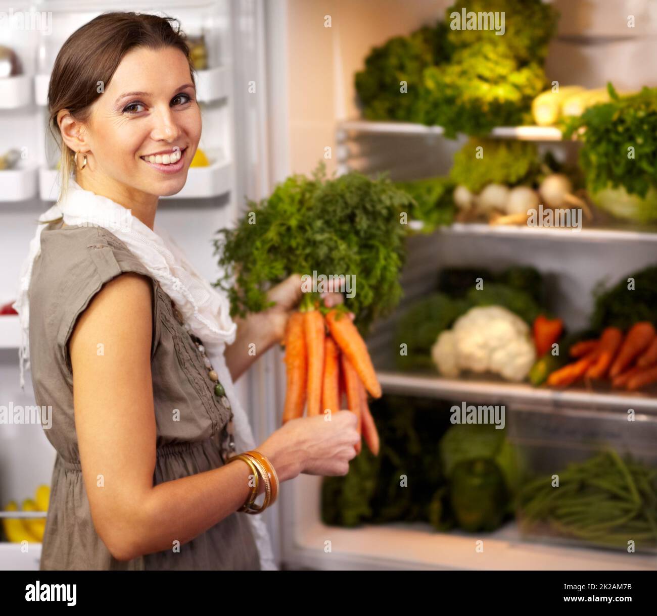 Shes stocked up on healthy food. Smiling woman adding some fresh
