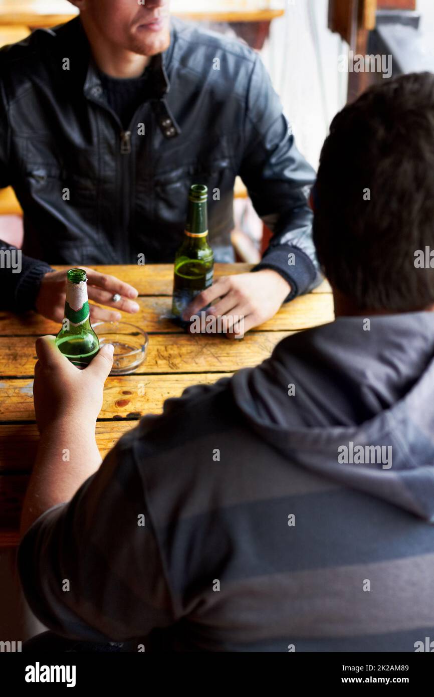 Cold beers and good times. Cropped image of two young men drinking beers at a restaurant. Stock Photo
