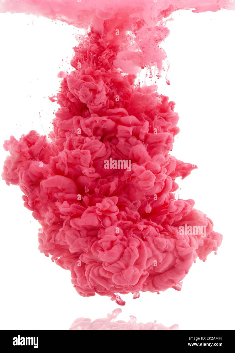 Colorful explosion. Studio shot of pink ink in water against a white background. Stock Photo