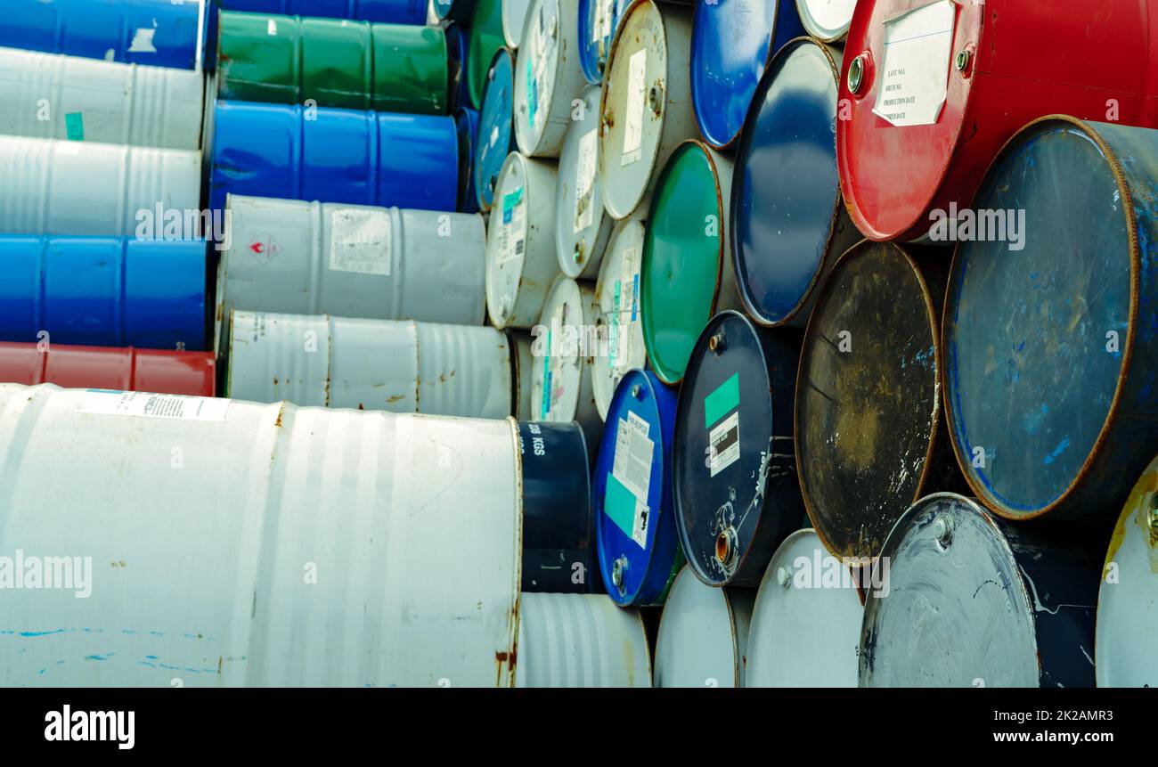 Old chemical barrels. Hazard chemical barrel with warning label. Steel tank of flammable liquid. Empty steel oil tank. Toxic waste warehouse. Hazard waste storage in factory. Metal brent oil drum. Stock Photo