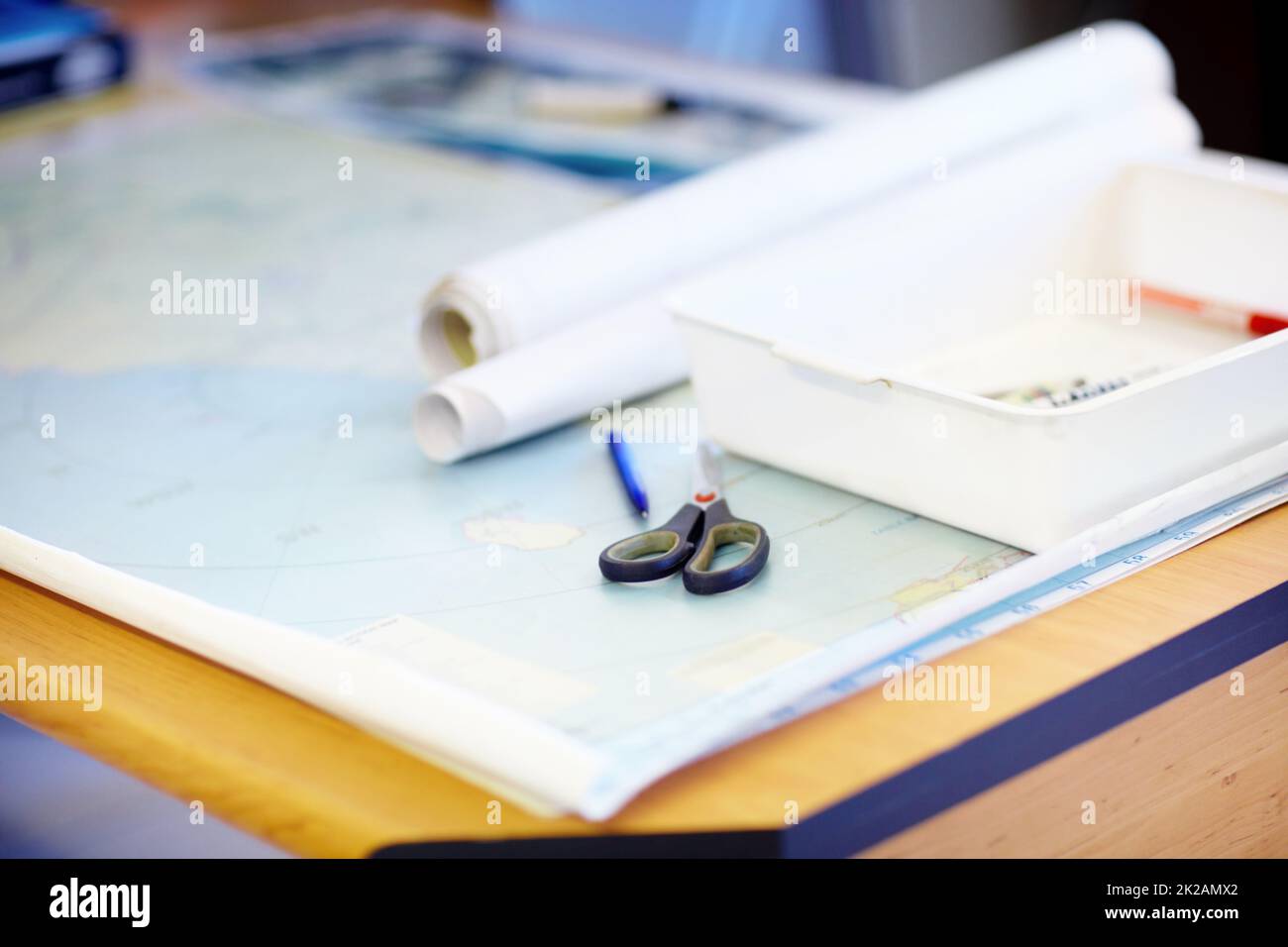 Lifeguards always need to have a map on hand. High angle shot of a map and stationary lying on a desk inside a lifeguard office. Stock Photo