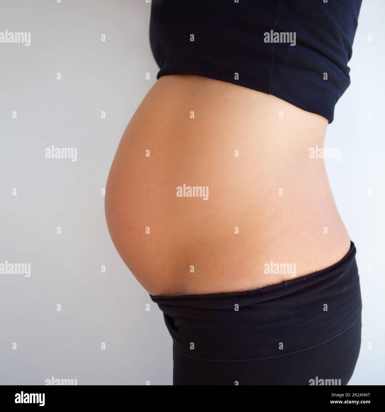 Pregnancy is beautiful. Cropped shot of a side angle view of pregnant womanamp039s stomach. Stock Photo