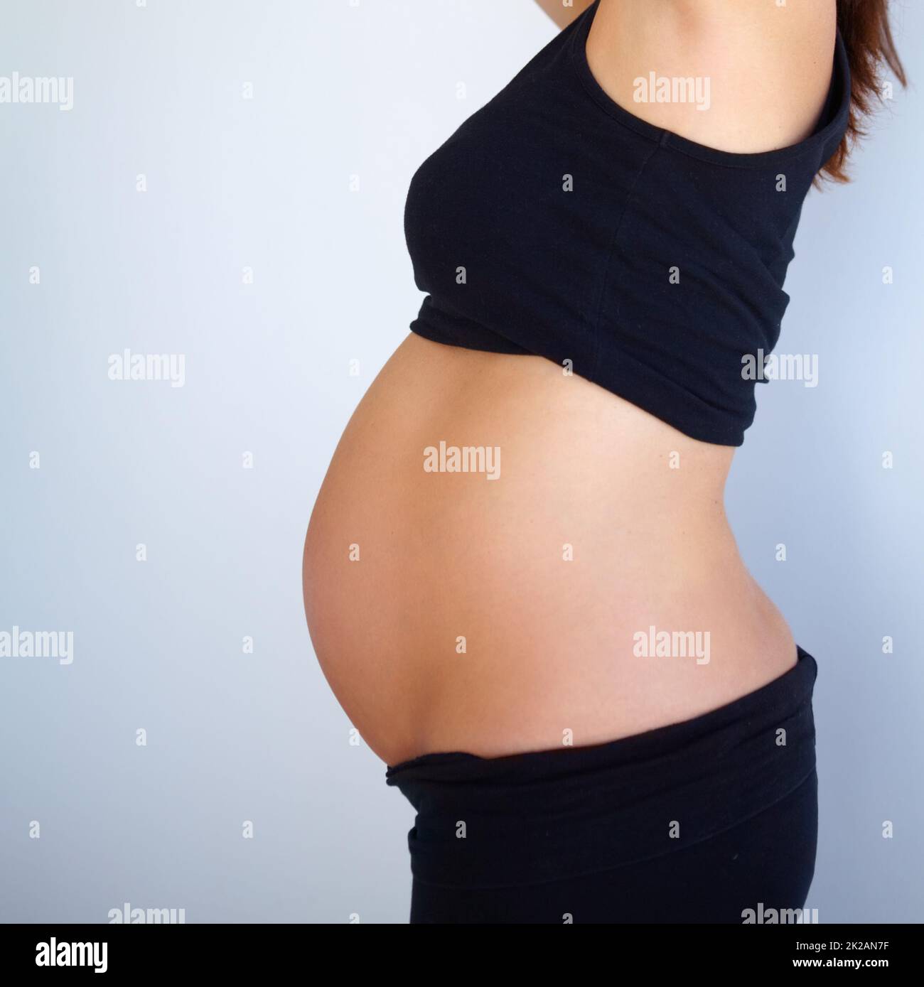 Proud of what my husband and I created. Side angle view of pregnant womanamp039s stomach. Stock Photo