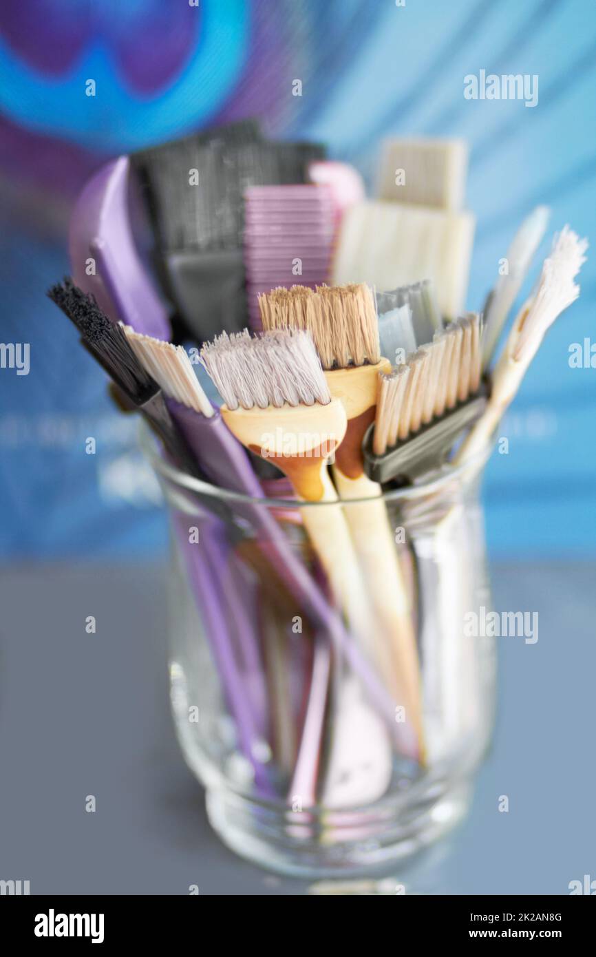 Let your hair be their canvas. A glass jar filled with hair colouring brushes. Stock Photo