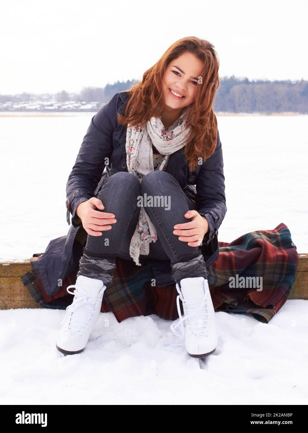 Winters my favourite time of year. Pretty teenage girl ready to go ice skating on a natural frozen lake outdoors. Stock Photo
