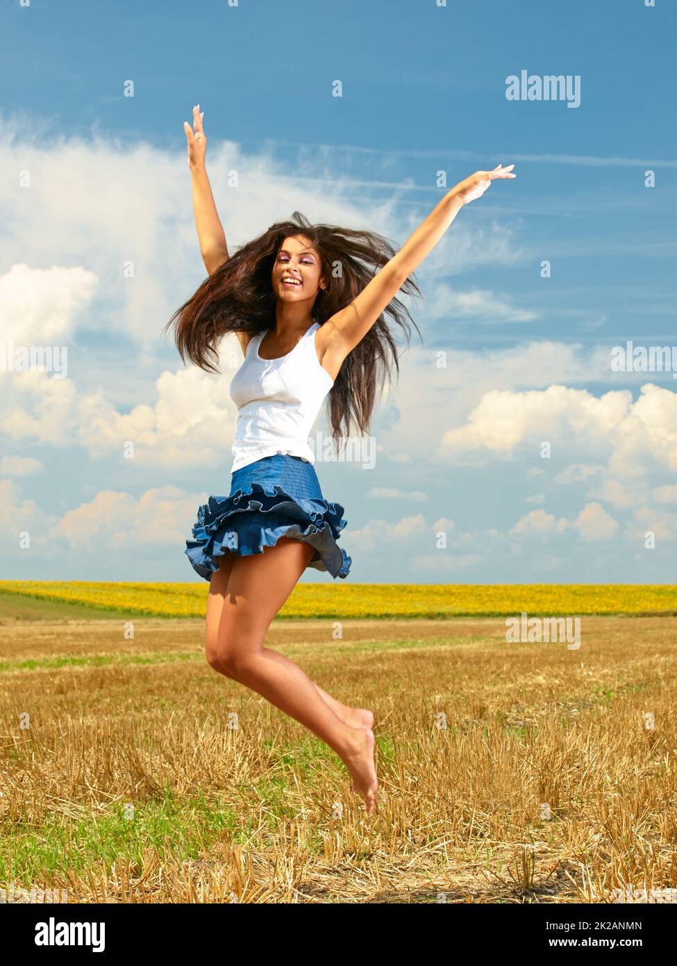 Im free. Shot of a beautiful young woman in the countryside with her arms outstretched in joy. Stock Photo